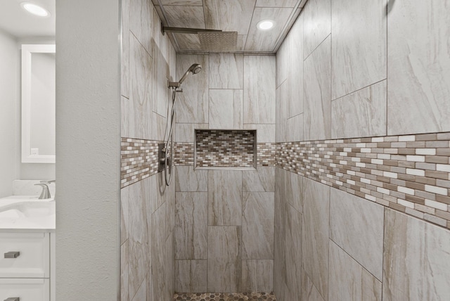 bathroom featuring recessed lighting, tiled shower, and vanity