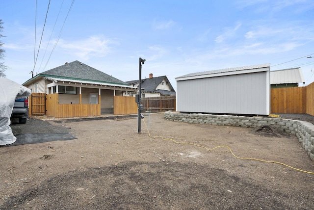 view of yard featuring a fenced backyard, a shed, and an outbuilding