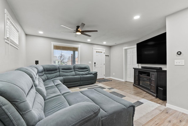 living area featuring baseboards, light wood-type flooring, and recessed lighting