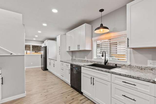 kitchen with a sink, light wood finished floors, white cabinetry, and dishwasher