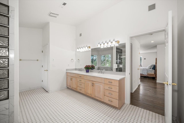 bathroom with connected bathroom, visible vents, a sink, and double vanity