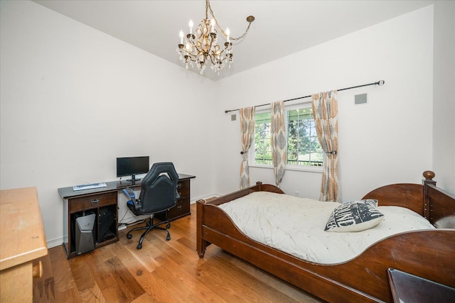 bedroom with a notable chandelier, baseboards, and wood finished floors