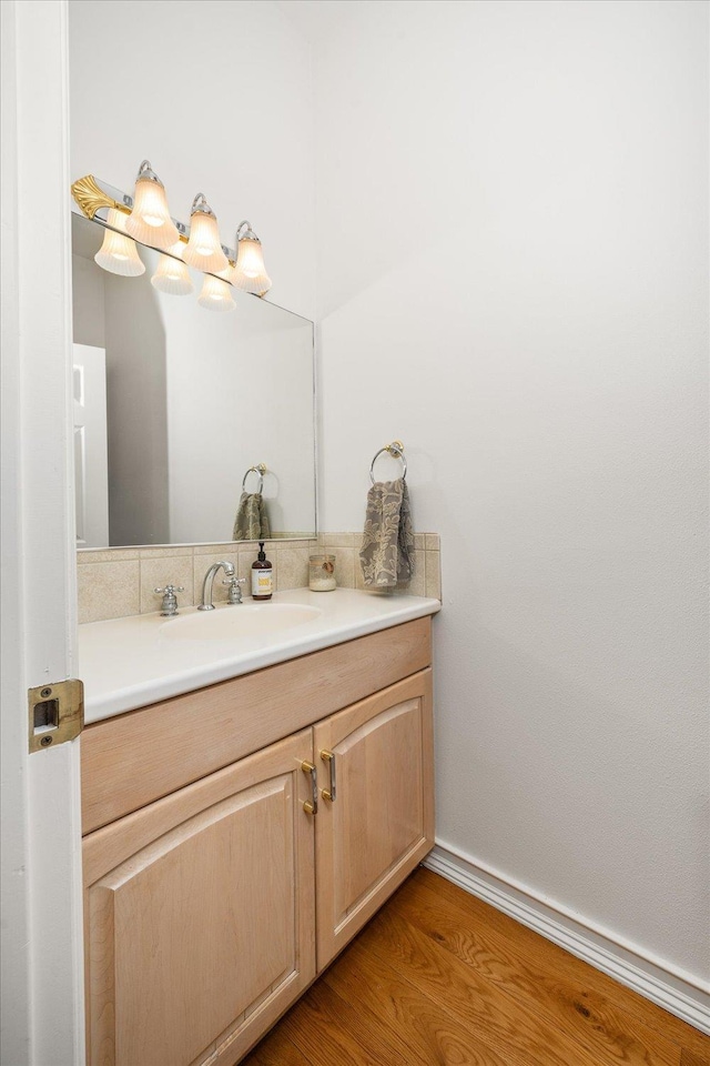 bathroom featuring wood finished floors, vanity, and baseboards