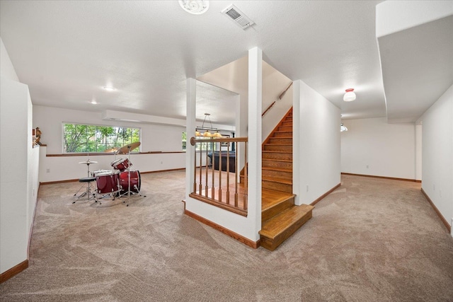 interior space with carpet, visible vents, a textured ceiling, and baseboards