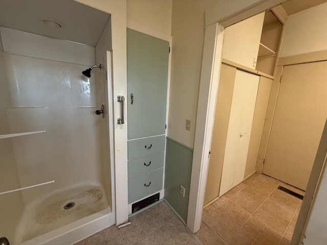 bathroom featuring a stall shower, visible vents, and wainscoting