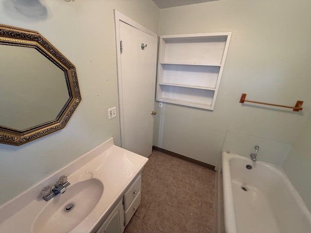 full bathroom with a bathing tub, baseboards, and vanity