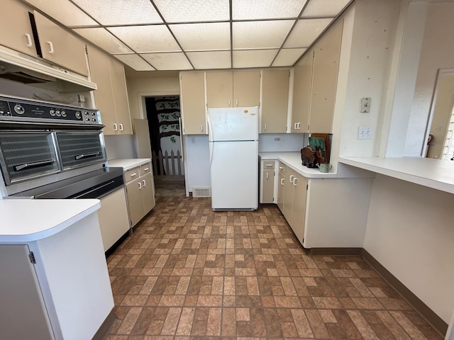 kitchen with a paneled ceiling, visible vents, light countertops, and freestanding refrigerator