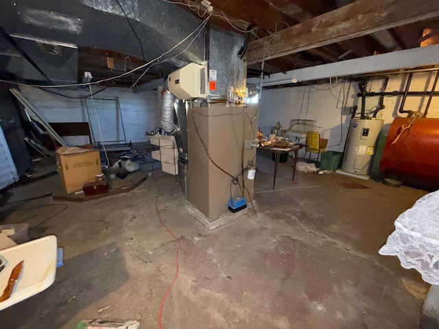 unfinished basement featuring water heater, heating unit, and heating fuel