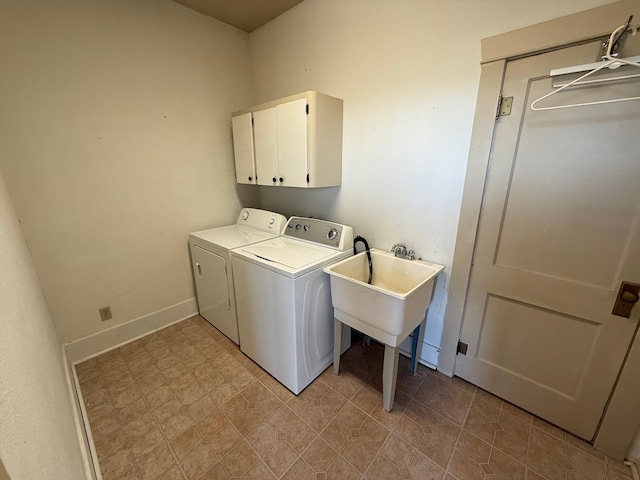 laundry area featuring cabinet space, baseboards, a sink, and independent washer and dryer