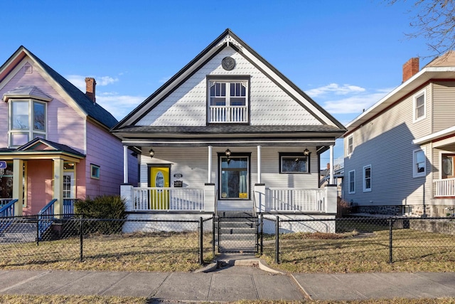 victorian house with a fenced front yard, covered porch, and a gate