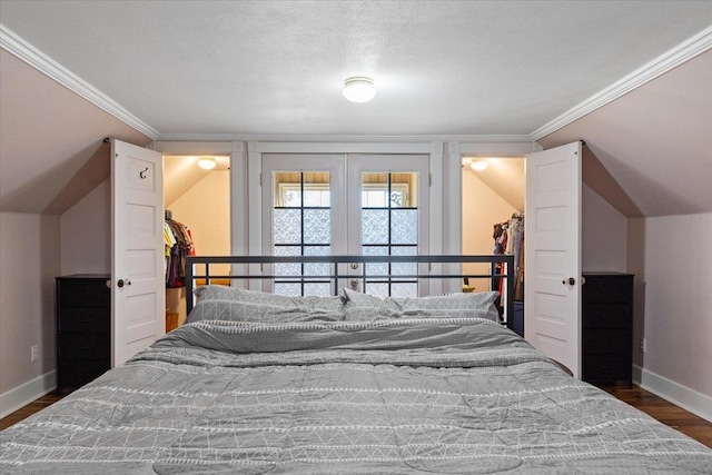 bedroom featuring crown molding, baseboards, vaulted ceiling, and wood finished floors