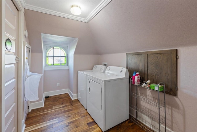 laundry area featuring crown molding, washing machine and dryer, wood finished floors, laundry area, and baseboards