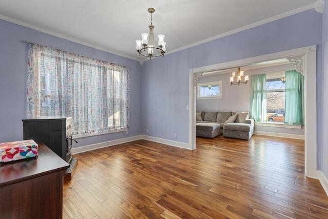 office space with an inviting chandelier, baseboards, ornamental molding, and wood finished floors