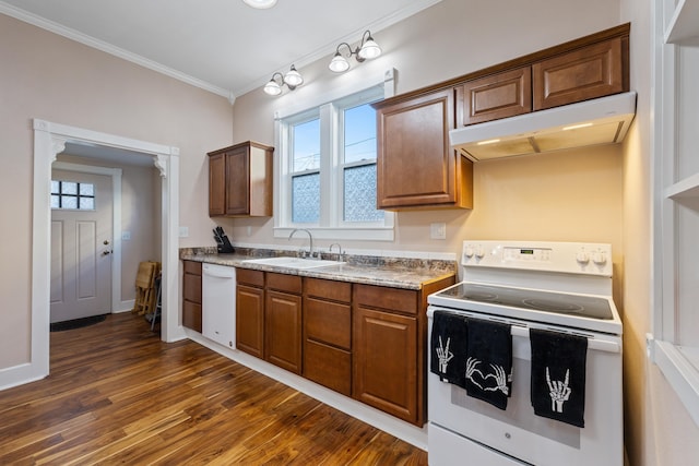 kitchen featuring white appliances, dark wood-style flooring, crown molding, under cabinet range hood, and a sink