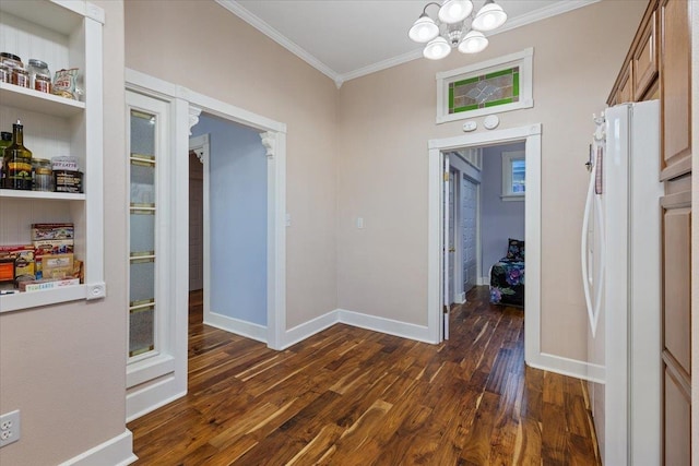 interior space featuring dark wood-style floors, baseboards, crown molding, and an inviting chandelier