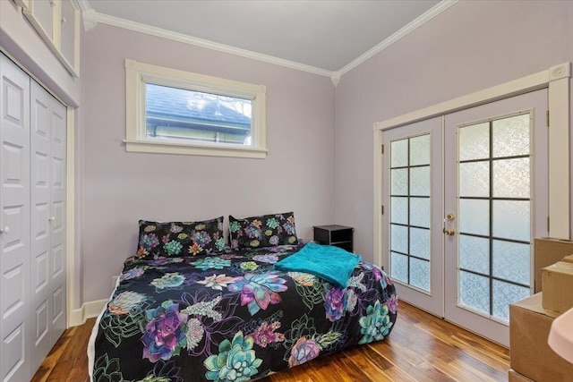 bedroom with a closet, wood finished floors, crown molding, and french doors