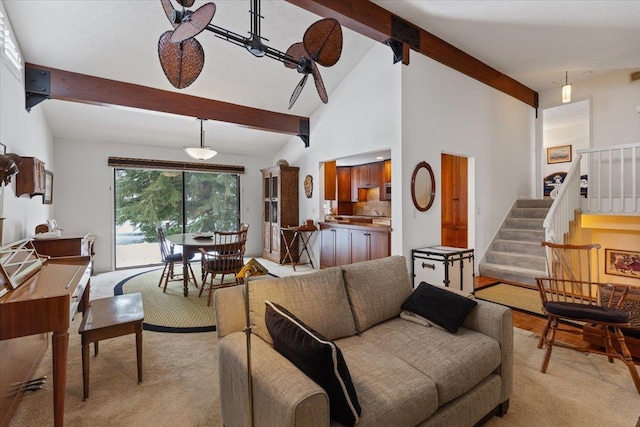 living area with high vaulted ceiling, stairway, beam ceiling, and light colored carpet