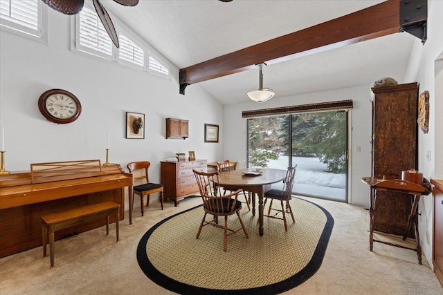 dining room with light colored carpet and lofted ceiling with beams