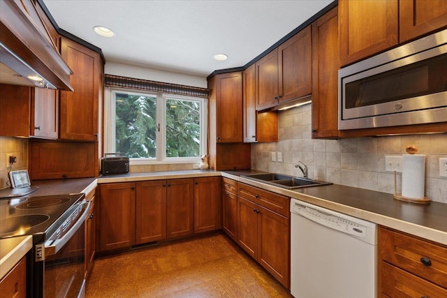 kitchen with light floors, stainless steel appliances, backsplash, a sink, and extractor fan