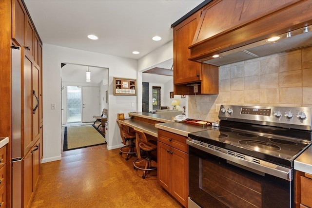 kitchen featuring decorative backsplash, brown cabinets, stainless steel electric range, and extractor fan