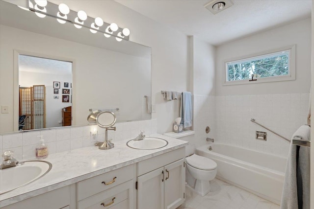 full bath featuring a tub to relax in, tasteful backsplash, a sink, and double vanity