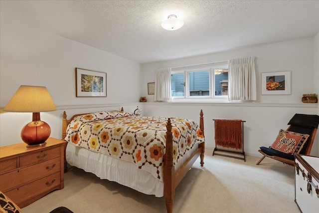 bedroom featuring a textured ceiling and light colored carpet