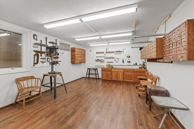 kitchen featuring dark wood-type flooring, brown cabinets, and a textured ceiling