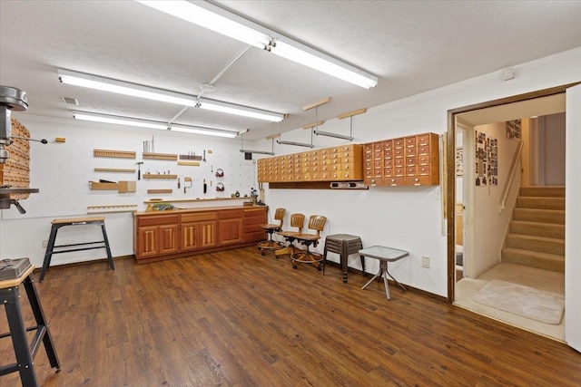 kitchen featuring a textured ceiling, dark wood finished floors, mail area, and brown cabinets