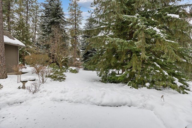 snowy yard featuring a garage