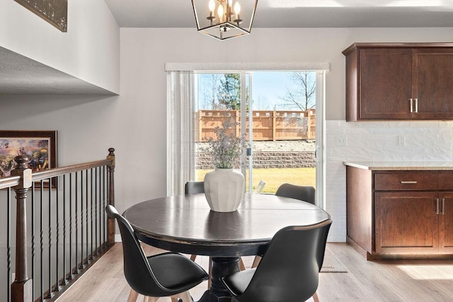 dining room with light wood finished floors and an inviting chandelier