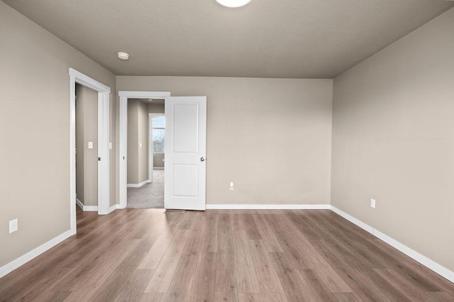 unfurnished room with baseboards and wood finished floors