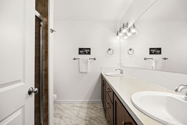 bathroom featuring double vanity, marble finish floor, baseboards, and a sink