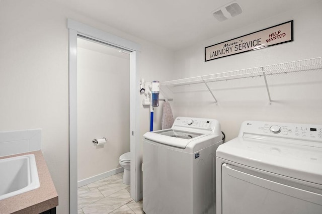 laundry room featuring laundry area, a sink, visible vents, marble finish floor, and washing machine and clothes dryer