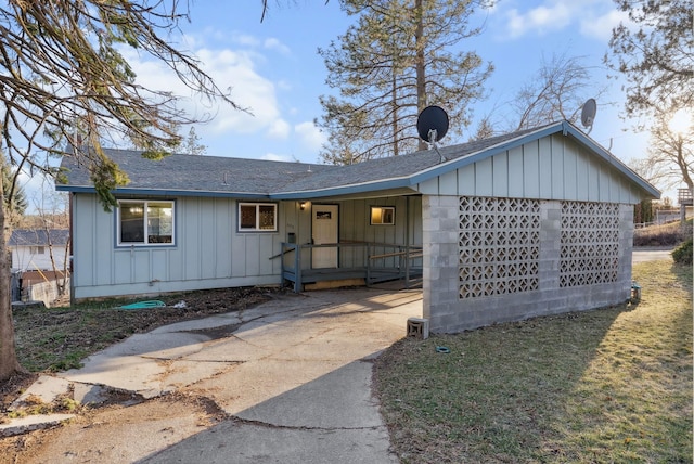 ranch-style home featuring a porch, board and batten siding, and roof with shingles