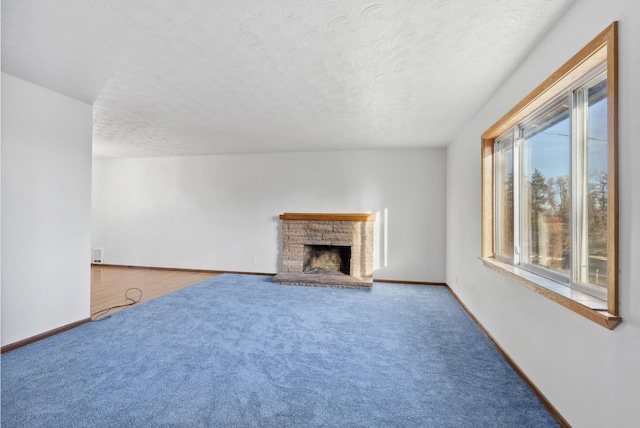 unfurnished living room with carpet, a textured ceiling, and baseboards