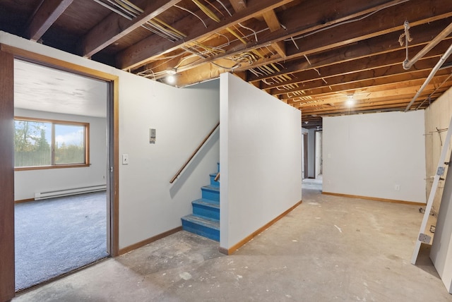 basement featuring baseboards, stairway, and baseboard heating