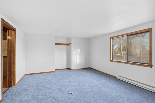 carpeted spare room with a baseboard heating unit and baseboards