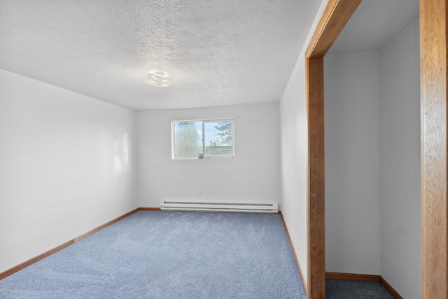 carpeted spare room with a textured ceiling, a baseboard radiator, and baseboards