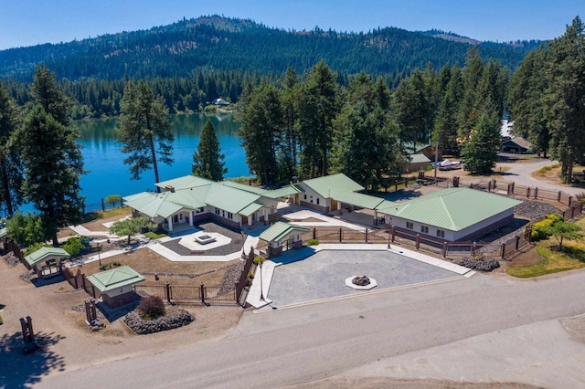 drone / aerial view with a water view and a forest view