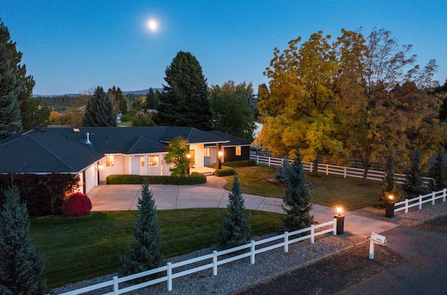 view of front of home with concrete driveway, a front yard, and fence