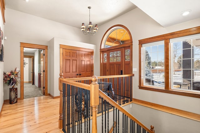 entryway featuring a chandelier, light wood-style floors, and baseboards