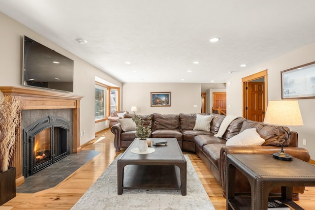 living area featuring a premium fireplace, baseboards, wood finished floors, and recessed lighting