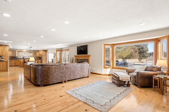 living room with light wood-type flooring, baseboards, and recessed lighting