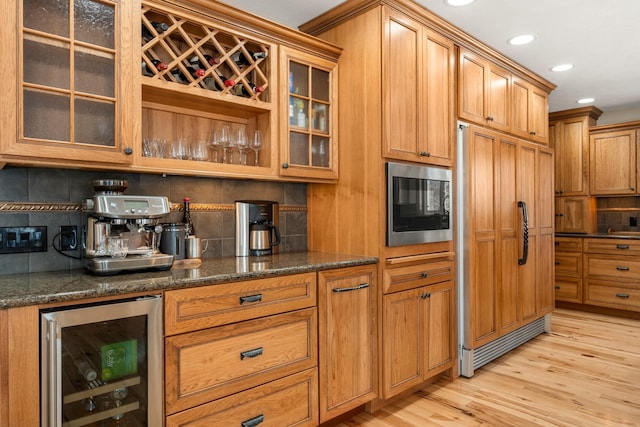 kitchen featuring wine cooler, backsplash, and built in appliances