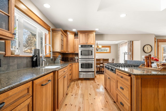 kitchen with stainless steel appliances, a healthy amount of sunlight, a sink, and a warming drawer