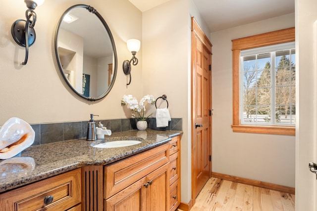 bathroom featuring vanity, baseboards, and wood finished floors