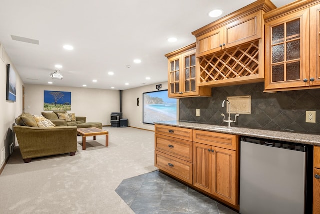 kitchen featuring dishwashing machine, a sink, tasteful backsplash, dark carpet, and a wood stove