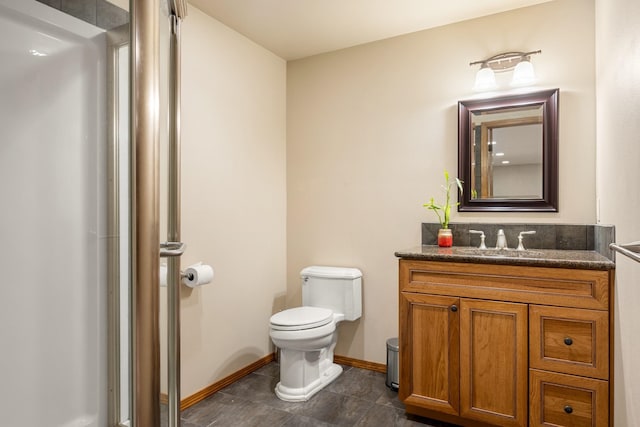 bathroom with baseboards, vanity, and toilet