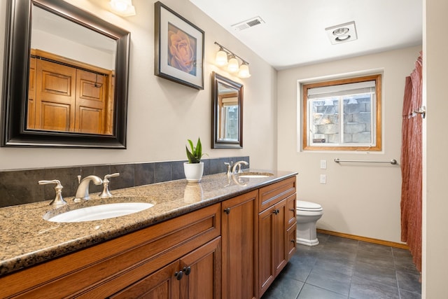 full bath with baseboards, a sink, toilet, and double vanity