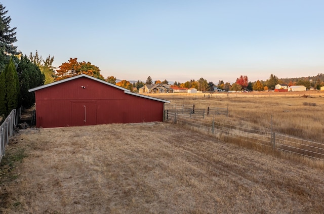 view of yard with an outbuilding, a barn, and fence